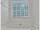 Soaking tub features white tile surround and chrome fixtures at 11407 Lenswood Ct, Charlotte, NC 28214