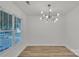 Bright, empty dining room with hardwood floors, modern lighting fixture, and a large window at 11407 Lenswood Ct, Charlotte, NC 28214