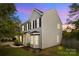 Side view of a two-story home with light siding, black shutters, green lawn, and minimal landscaping at 11407 Lenswood Ct, Charlotte, NC 28214