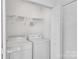 Bright laundry room featuring a white washer, dryer, and ample shelving at 11407 Lenswood Ct, Charlotte, NC 28214