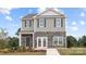 Charming two-story home featuring stone accents and gray siding, complemented by professionally landscaped front yard at 12145 Lady Bell Dr, Charlotte, NC 28278