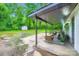 The covered back patio is virtually staged with cozy seating, offering a relaxing outdoor space at 1224 E Woodlawn Rd, Charlotte, NC 28209