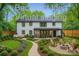 The backyard is virtually staged and transformed into an inviting outdoor oasis with lush landscaping and a fire pit at 1224 E Woodlawn Rd, Charlotte, NC 28209
