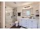 Bathroom featuring a glass shower, white vanity with dual sinks, and modern fixtures at 1224 E Woodlawn Rd, Charlotte, NC 28209