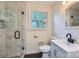 Bright bathroom featuring a glass-enclosed shower, modern vanity, and window offering natural light at 1224 E Woodlawn Rd, Charlotte, NC 28209