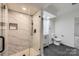 Modern bathroom featuring a marble tiled shower, modern vanity, and sleek, dark tile flooring at 1224 E Woodlawn Rd, Charlotte, NC 28209