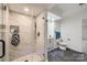 Staged bathroom with a marble tiled shower, modern vanity, and sleek, dark tile flooring at 1224 E Woodlawn Rd, Charlotte, NC 28209