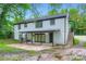Back exterior of a two-story white brick home featuring a covered patio and access stairs at 1224 E Woodlawn Rd, Charlotte, NC 28209