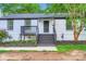 Charming front porch with black wooden steps, and decorative plants at 1224 E Woodlawn Rd, Charlotte, NC 28209