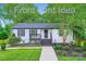 Charming home with manicured front yard, featuring a cozy porch and refreshed landscaping, creating curb appeal at 1224 E Woodlawn Rd, Charlotte, NC 28209