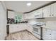 Bright kitchen featuring white cabinets, updated appliances, and a mosaic backsplash at 1224 E Woodlawn Rd, Charlotte, NC 28209