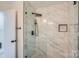 Modern glass shower enclosure with marble tiling, matte black hardware, and a rainfall showerhead at 1224 E Woodlawn Rd, Charlotte, NC 28209