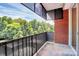 Spacious balcony with railing and outdoor view of the surrounding trees and neighborhood at 1300 Queens Rd # 409, Charlotte, NC 28207