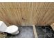Modern commode in a bathroom featuring wood slat-look tile and black hexagon floor tile at 1300 Queens Rd # 409, Charlotte, NC 28207