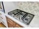 Close up of modern cooktop with stainless steel appliances, custom backsplash, and quartz countertops at 1300 Queens Rd # 409, Charlotte, NC 28207