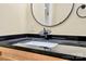 Bathroom sink featuring black countertop, unique faucet, and black-framed mirror at 1300 Queens Rd # 409, Charlotte, NC 28207