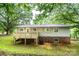 Back exterior of a split-level house featuring a wooden deck, gray siding, and a brick foundation at 1309 Poplar Cir, Newton, NC 28658