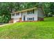 Split-level home with a front yard and a one-car garage, featuring a brick base and gray siding at 1309 Poplar Cir, Newton, NC 28658