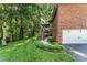 Expansive backyard featuring a brick home, lush landscaping, and convenient garage access at 1622 Brookstone Dr, Hickory, NC 28602
