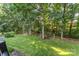 Lush backyard with mature trees, landscaping, and private seating areas. Shed in background at 1622 Brookstone Dr, Hickory, NC 28602