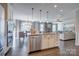 Bright open kitchen featuring a central island with a sink, stainless steel appliances, and hardwood flooring at 1630 Riddle Ext, Clover, SC 29710
