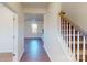 Inviting foyer with hardwood flooring, view to the living room, and staircase with carpeted treads at 1821 Augustine St, Monroe, NC 28112