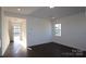 Spacious living room with dark hardwood flooring, bright natural light, and crisp white walls at 1821 Augustine St, Monroe, NC 28112