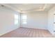 Bright and airy main bedroom featuring neutral carpet, tray ceiling, and natural light at 1821 Augustine St, Monroe, NC 28112