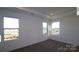Bright main bedroom offering plush carpeting, three large windows, and trey ceiling at 1821 Augustine St, Monroe, NC 28112