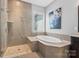 Bright bathroom featuring a soaking tub with a window, a walk-in shower, and elegant tile work at 2052 Masons Bend Dr, Fort Mill, SC 29708