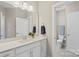 Well-lit bathroom with a single sink vanity, quartz countertops, a modern mirror, and a door to the water closet at 2052 Masons Bend Dr, Fort Mill, SC 29708