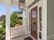 Welcoming front porch featuring a glass-paneled door, white railing, and a modern hanging lantern at 2052 Masons Bend Dr, Fort Mill, SC 29708