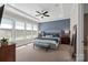 Main bedroom suite featuring tray ceilings, carpet floors, and natural light from large windows at 2052 Masons Bend Dr, Fort Mill, SC 29708