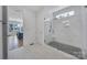 A spacious bathroom with a glass enclosed shower, marble tiling, and open doorway to bedroom at 2148 Nims Village Dr, Fort Mill, SC 29715