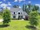 Stunning two-story modern farmhouse with black trim, lush lawn, and mature trees on a sunny day at 2148 Nims Village Dr, Fort Mill, SC 29715