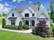 Charming modern farmhouse with black window trim, covered porch, and landscaped front yard at 2148 Nims Village Dr, Fort Mill, SC 29715