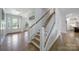 Bright and airy home foyer featuring hardwood floors, white trim, and a staircase with wood and white railings at 2148 Nims Village Dr, Fort Mill, SC 29715