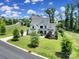 A daytime aerial shot of a beautifully landscaped home on a lush green lot with mature trees and a winding street at 2148 Nims Village Dr, Fort Mill, SC 29715