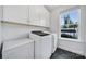Practical laundry room includes modern washer and dryer units, ample storage, and a window at 2148 Nims Village Dr, Fort Mill, SC 29715