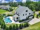 Aerial view of a large white home with a pool, hot tub, and a basketball hoop over the driveway at 2148 Nims Village Dr, Fort Mill, SC 29715