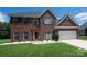 Charming brick home features a manicured lawn, red front door, and two-car garage at 219 Harrowfield Hts, York, SC 29745