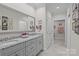Elegant bathroom with double granite vanity, large mirror, and a doorway leading to a bright, tiled shower area at 2484 Early Richmond Ct, Denver, NC 28037