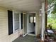 Covered porch entryway with white post and screen door at 30497 Orchard Ln, Albemarle, NC 28001