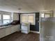 This kitchen has white cabinets, a gas range and a refrigerator at 30497 Orchard Ln, Albemarle, NC 28001