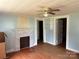 Living room with decorative fireplace, hardwood floors and ceiling fan at 30497 Orchard Ln, Albemarle, NC 28001