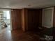 A wood paneled living room leads to the kitchen and another room at 30497 Orchard Ln, Albemarle, NC 28001