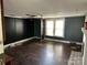 A spacious living room with dark wood paneling and a ceiling fan at 30497 Orchard Ln, Albemarle, NC 28001