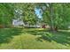 Spacious backyard with large lawn, mature trees, and wooden playset perfect for outdoor activities at 3165 Pendleton Ave, Charlotte, NC 28210