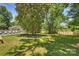 Expansive backyard featuring a sparkling pool, lush lawn, mature trees, and a charming playhouse at 3165 Pendleton Ave, Charlotte, NC 28210