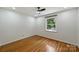 Bright bedroom offers gleaming hardwood floors, a ceiling fan, and a large window with a backyard view at 3165 Pendleton Ave, Charlotte, NC 28210